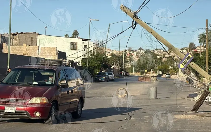 Postes dañados por choque quedan colgando y ponen en riesgo a vecinos