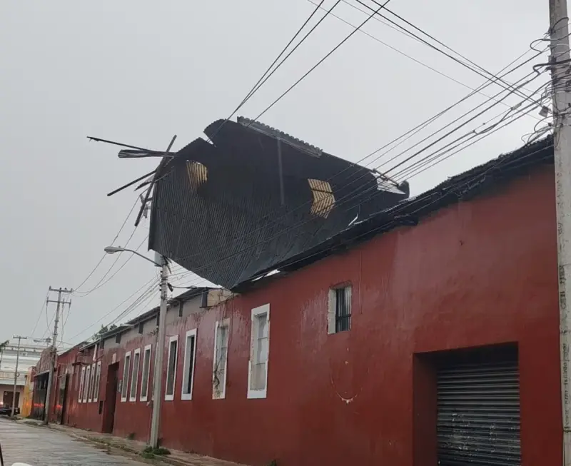Turbonada deja techo de lámina colgado sobre cables eléctricos en el centro de Mérida