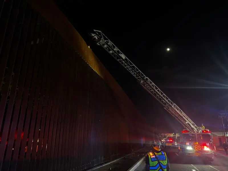 Bomberos bajan a hombre que subió hasta lo alto del cerco fronterizo en Mexicali